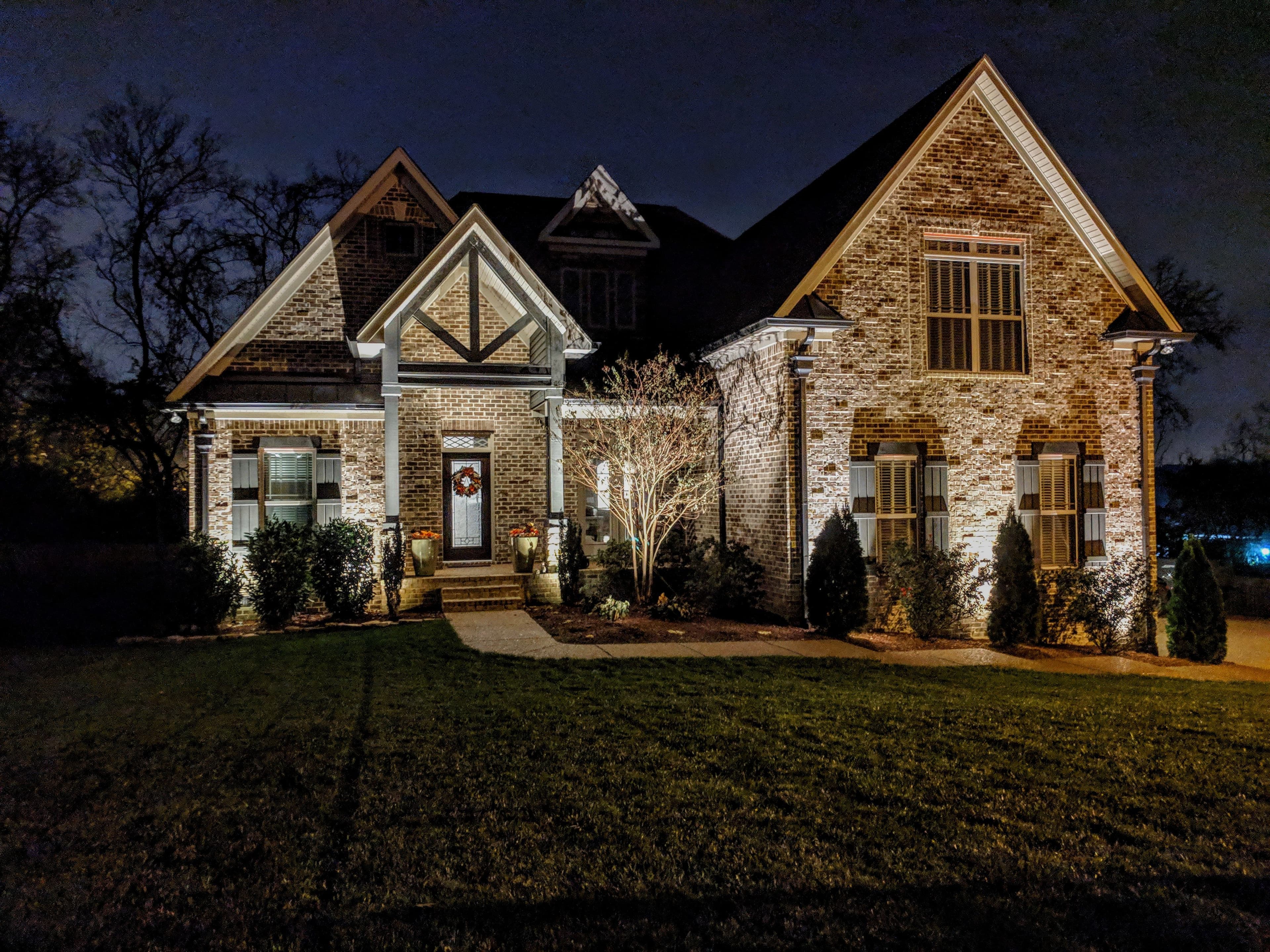 Professional landscape lighting installation showcasing uplighting technique on home exterior - Light Guys Auburn Alabama