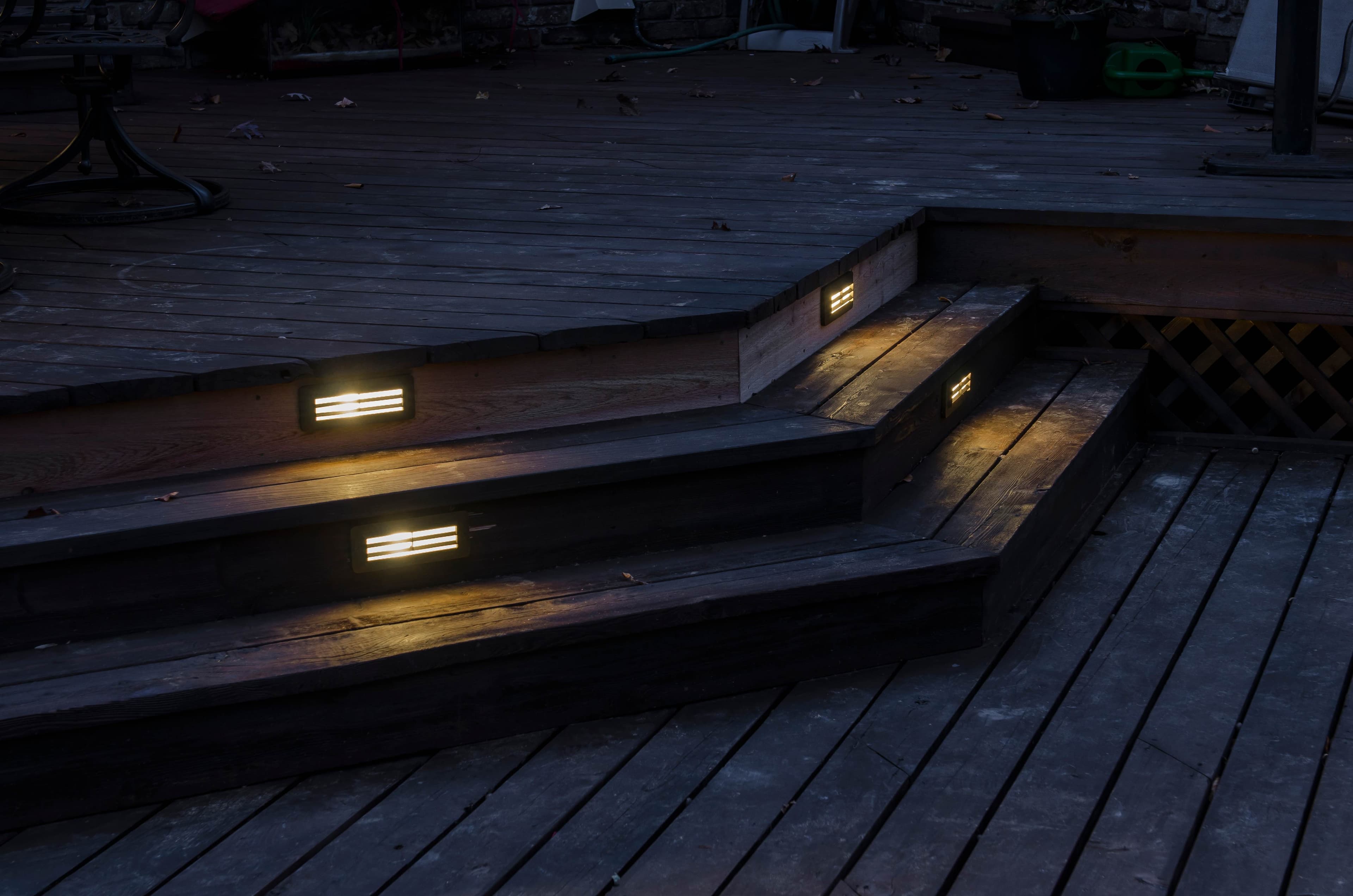 Deck step lighting at night showing recessed lights in wooden deck stairs for safety and ambiance in Auburn Alabama