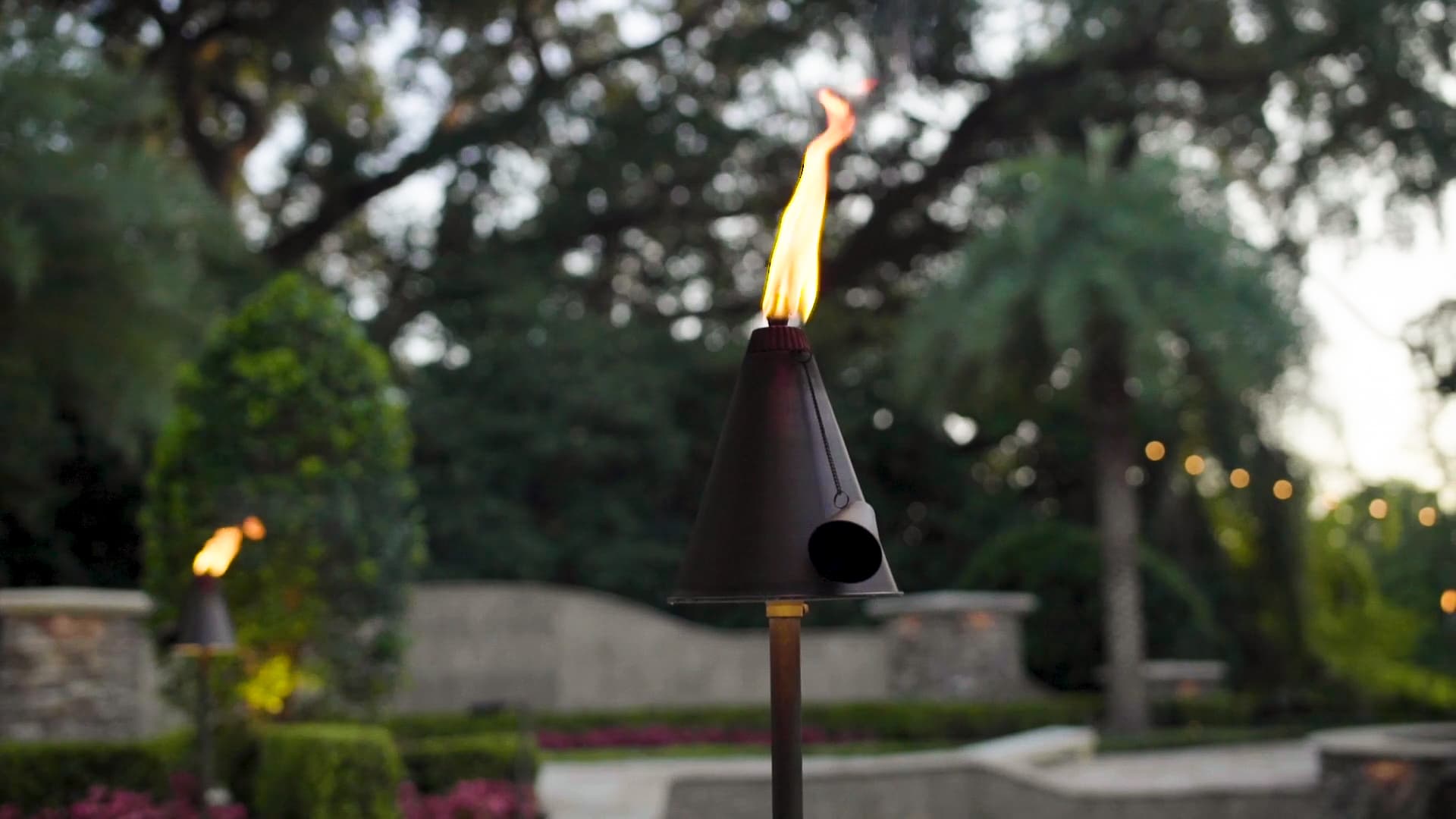 Tiki Torch Event Lighting Artistic shot of tiki torch-style path light with flame at dusk showing ambient outdoor lighting for events in Auburn Alabama
