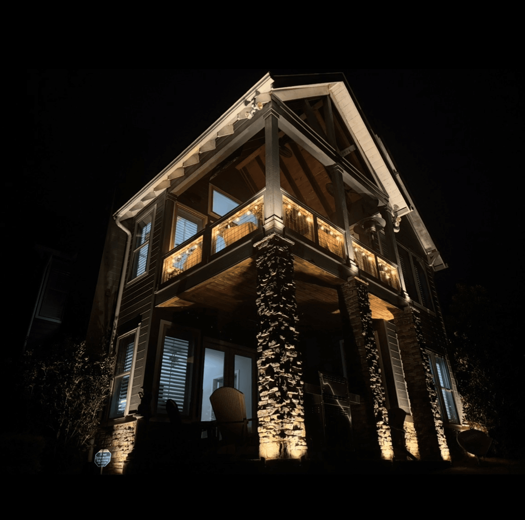 Lakefront Home Stone Column Lighting Modern lakefront home with dramatic stone column uplighting