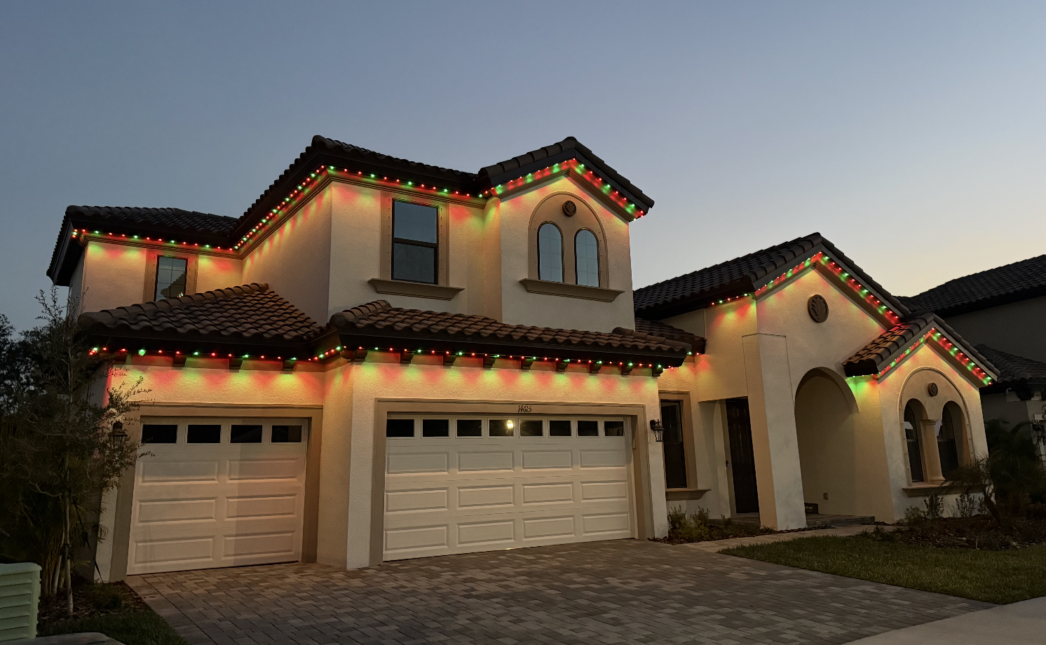 Traditional red and green Christmas lighting on Mediterranean home