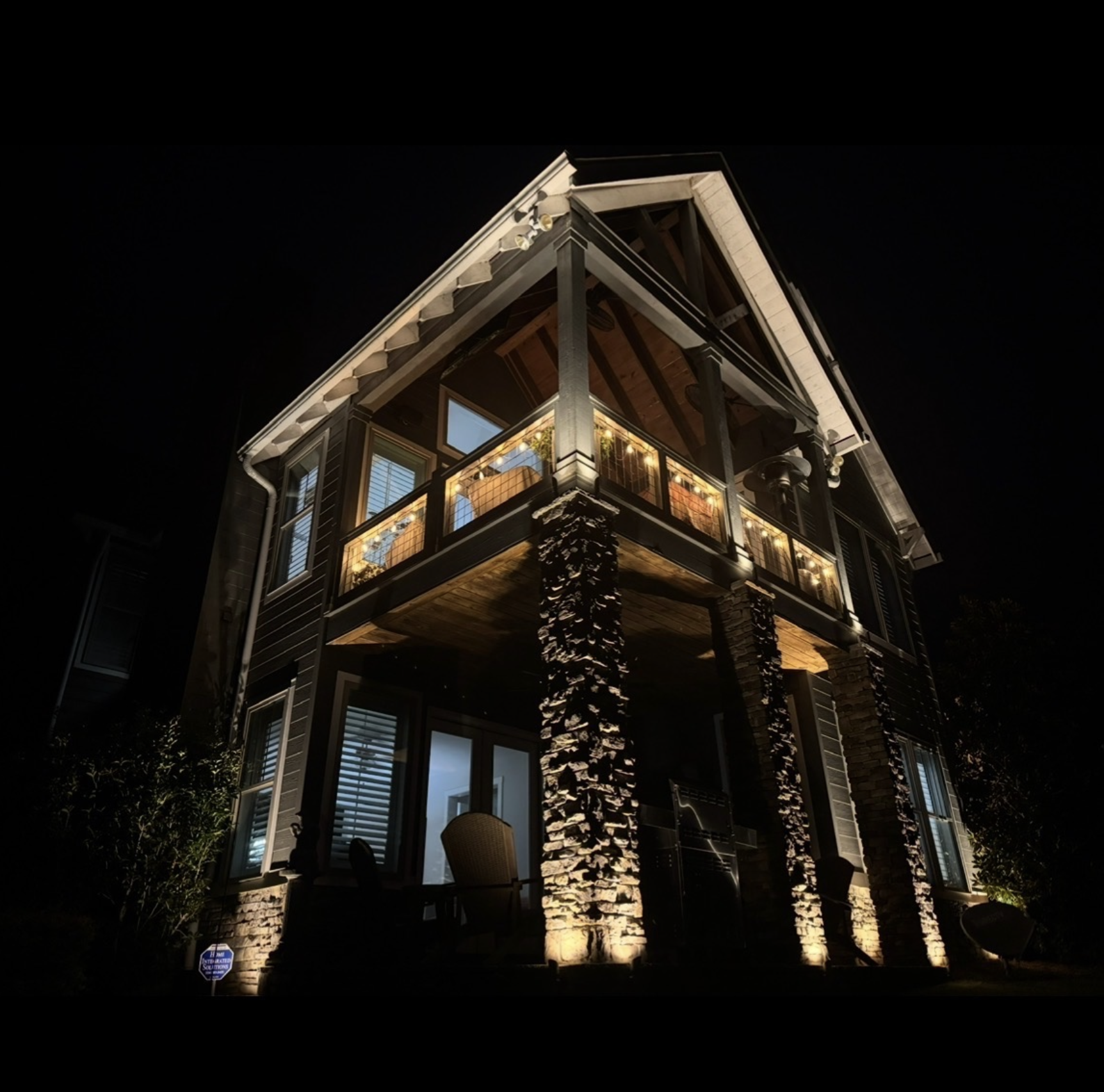 Lakefront Home Stone Column Lighting Modern lakefront home with dramatic stone column uplighting