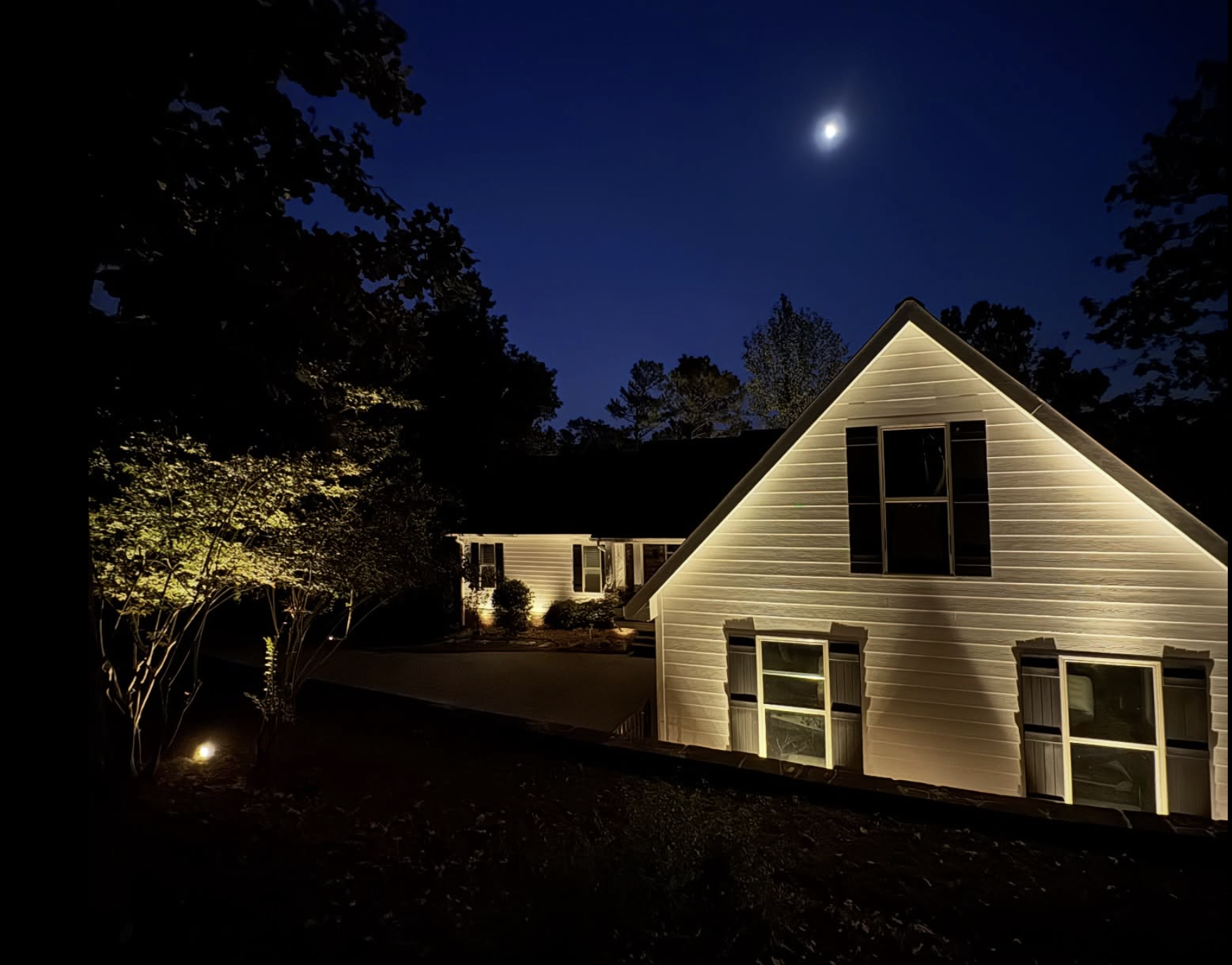 Tree Uplighting Under Moonlight White home with tree uplighting under moonlight